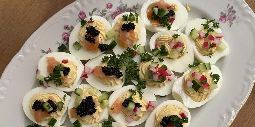DDR Klassiker: gefüllte Eier mit Lachs, Gurke und Radieschen auf einem Porzellanteller