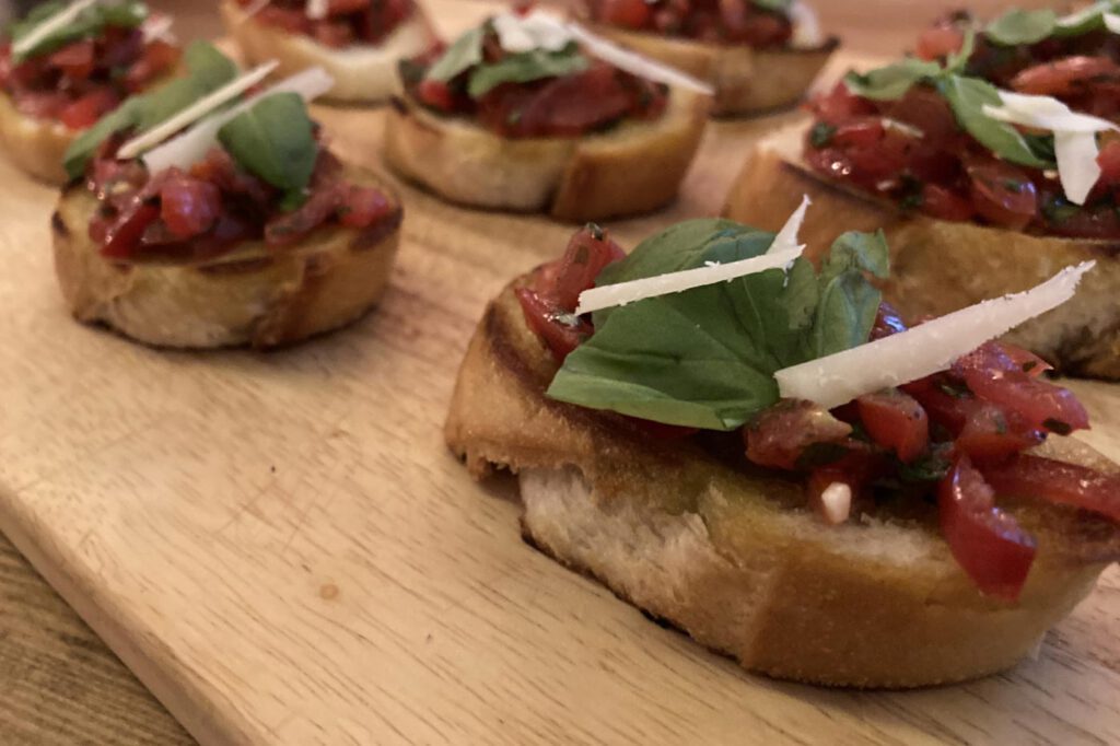 Geröstete Brotscheiben mit Tomaten-Basilikum-Belag