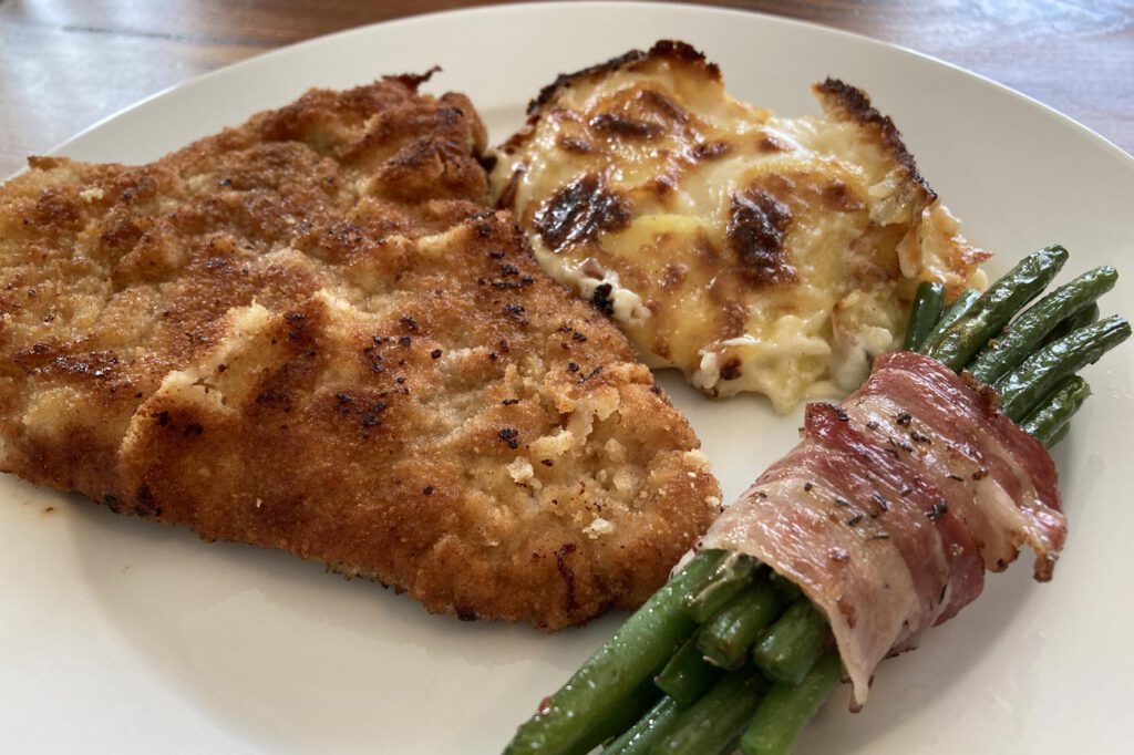 Schweineschnitzel mit Bohnen im Speckmantel und Kartoffelgratin