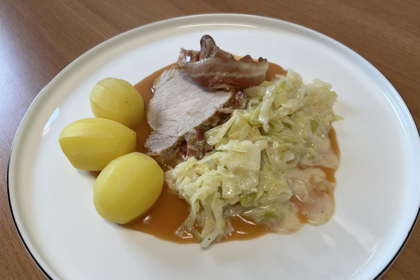 Schweinerückenbraten im Speckmantel mit Rahmwirsing und Salzkartoffeln