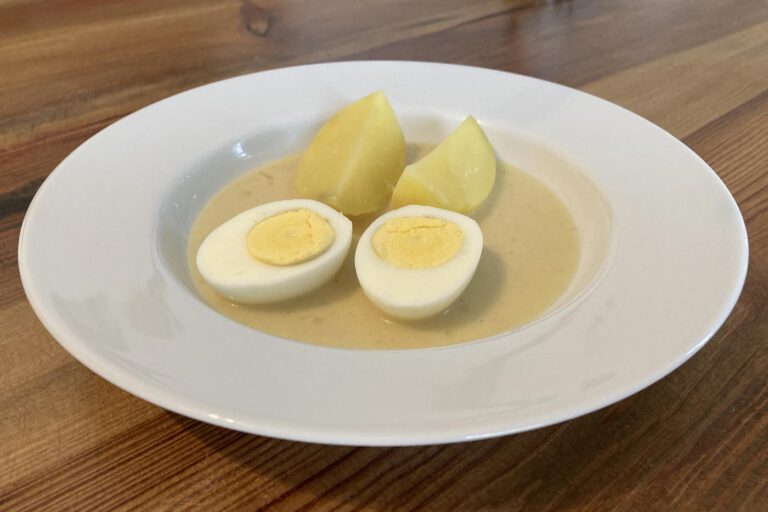 Hart gekochte Eier in süßsaurer Senfsoße mit Speck und Zwiebeln, dazu Salzkartoffeln